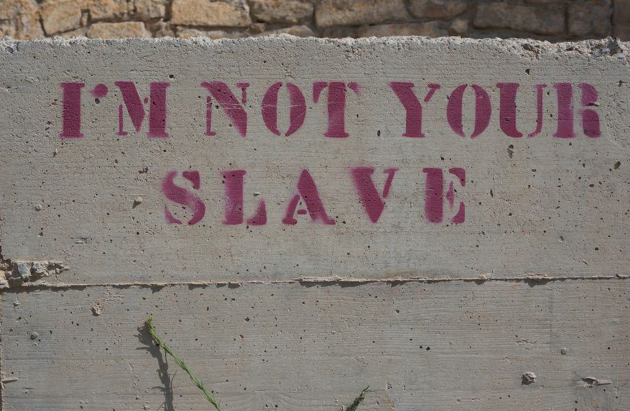 Lagos, Portugal things to do, stencil in red on stone wall reading "I'm not your slave"