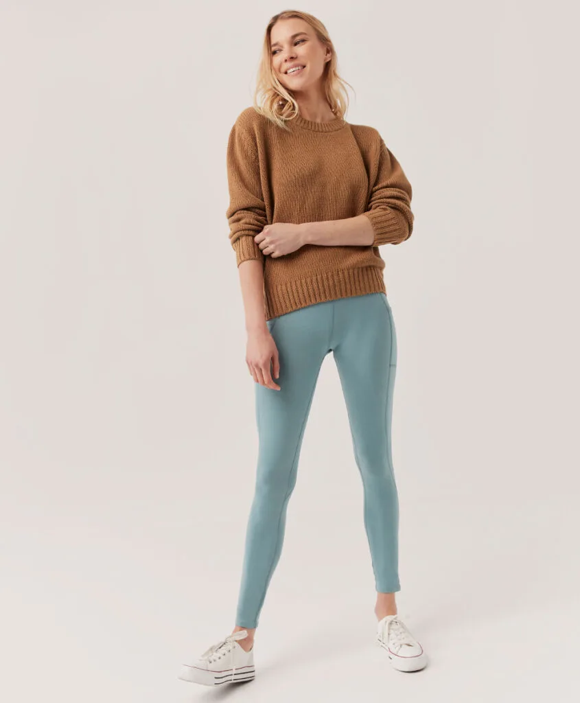 most sustainable yoga brands, woman posing in leggings and sweater