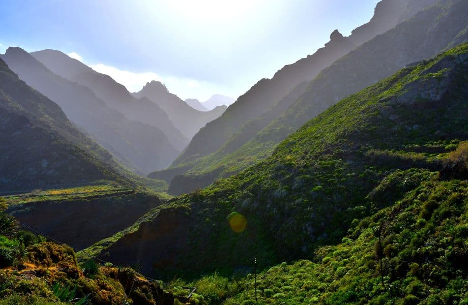best hiking trails in Tenerife, green mountain valley with view of many more mountains in the distance on a bright sunny day