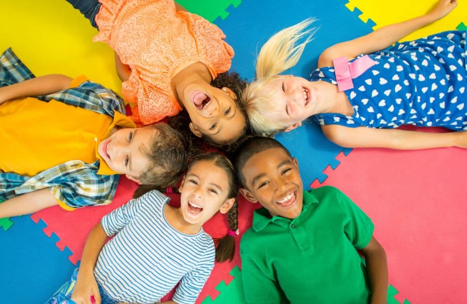kid-friendly resorts in Wisconsin, group of smiling kids lying in a circle with heads together in center