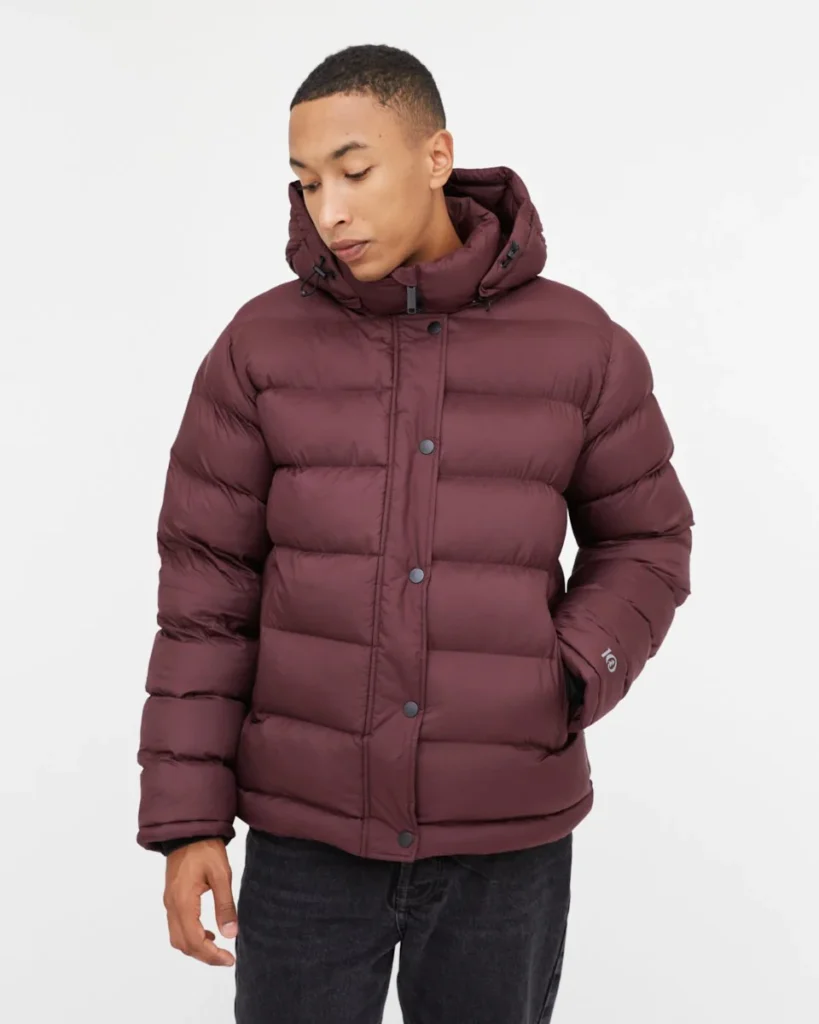 best sustainable winter jackets, person in maroon winter puffer jacket