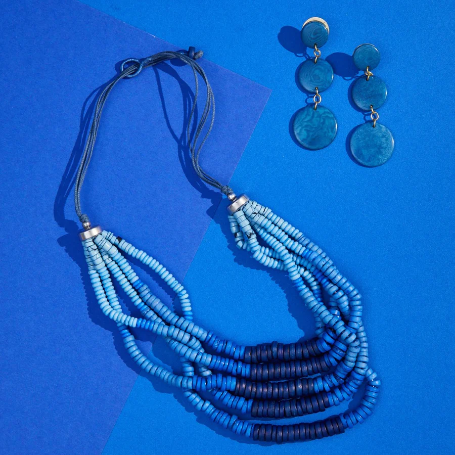 fun sustainable jewelry brands, blue beed necklace and matching blue earrings on blue background