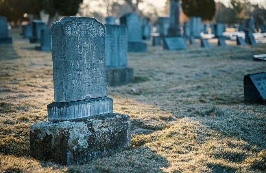 haunted cemeteries in Wisconsin, gravestone on a frosty morning with more graves behind