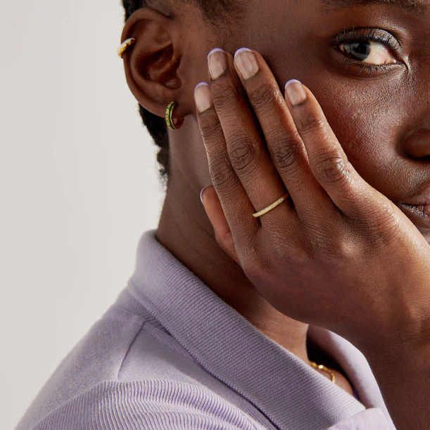 amazing ethically made jewelry brands, black woman resting hand on side of face to show off gold ring