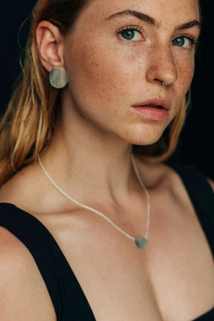 European eco jewelry brands, woman wearing matching round green earrings and necklace