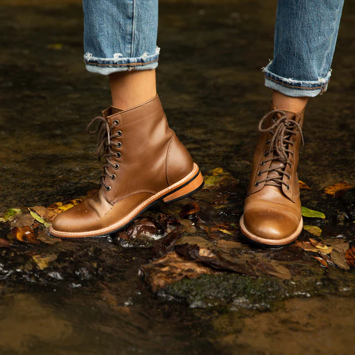 sustainable rain boots, person wearing brown boots standing in a shallow river
