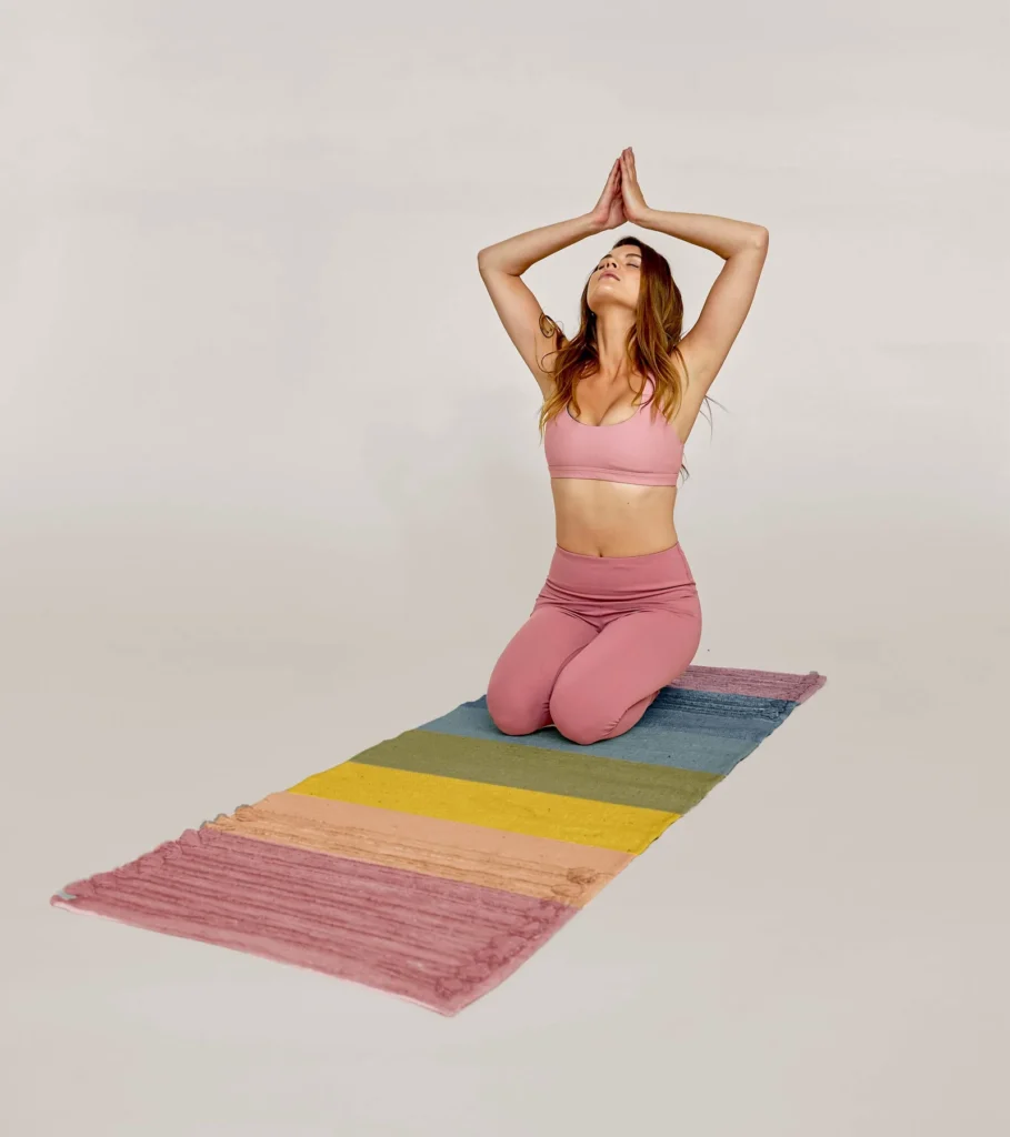 sustainable yoga mats, woman doing yoga on a rainbow colored fabric mat