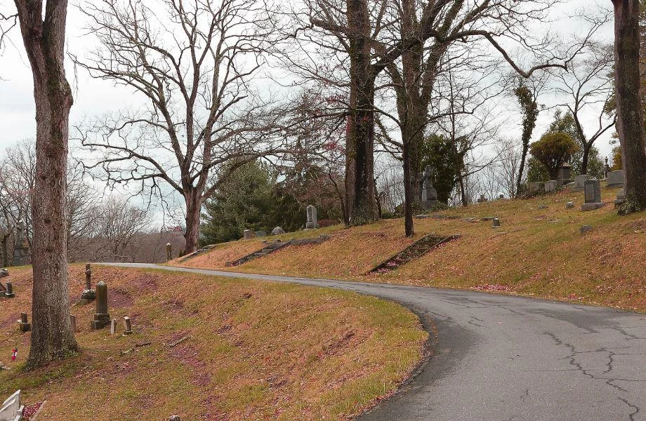 Where to find ghosts in Wisconsin, curved paved road through a cemetery on a grey day