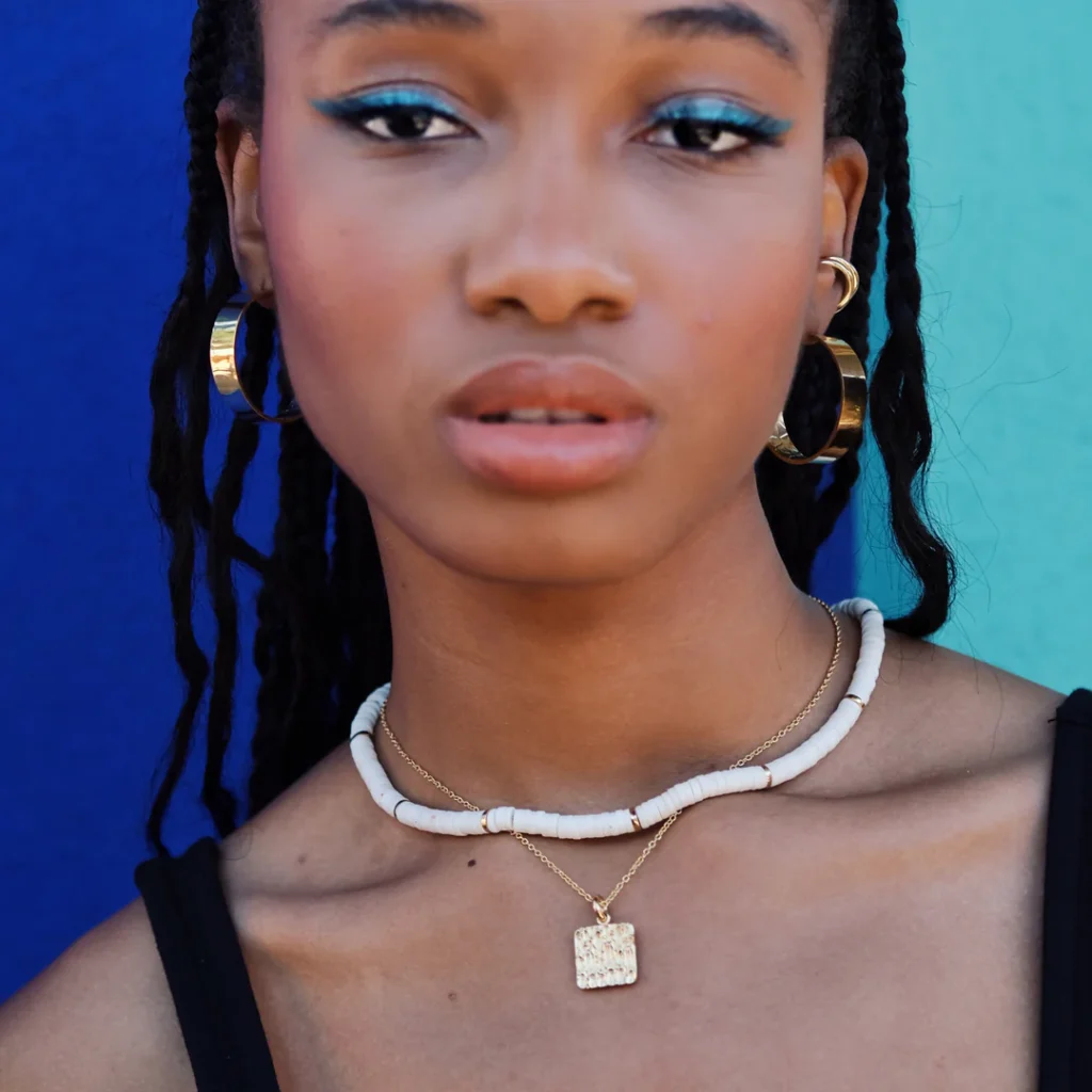 best eco-friendly jewelry brands, black woman wearing earrings and two necklaces