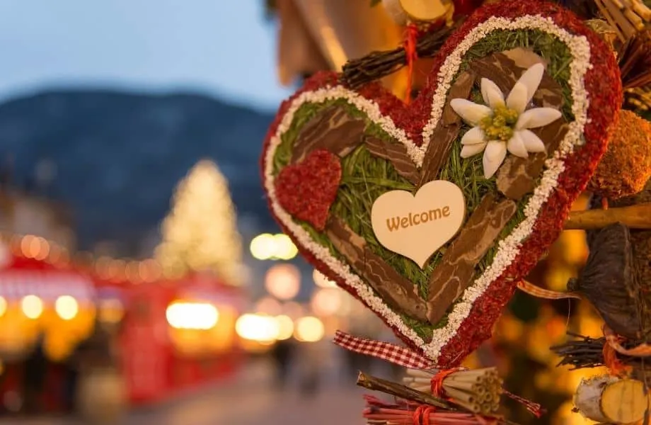 best Christmas markets in Wisconsin, heart decoration reading 'Welcome' with lit up Christmas market in background