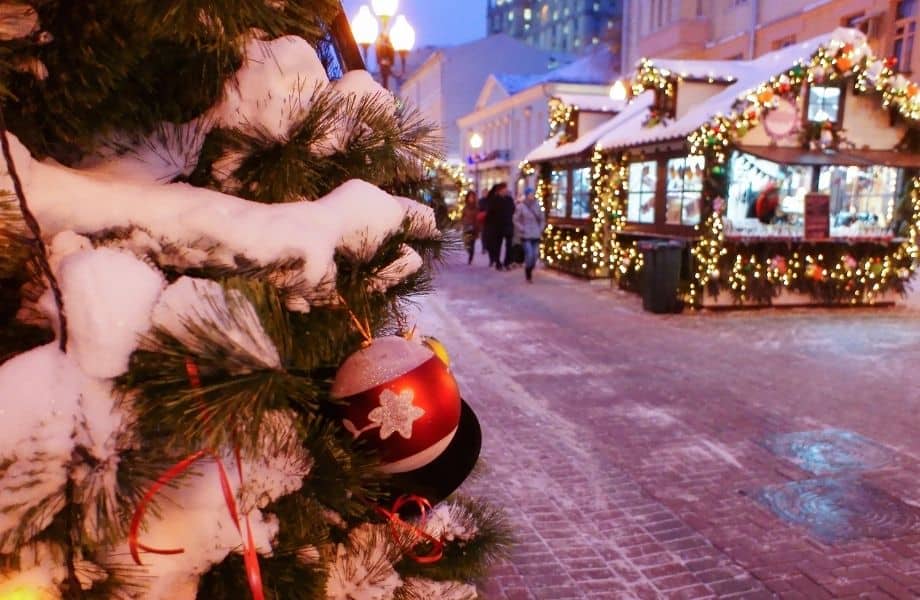 Amazing Wisconsin Christmas markets, market stalls under snow in background with snow Christmas tree in forefront