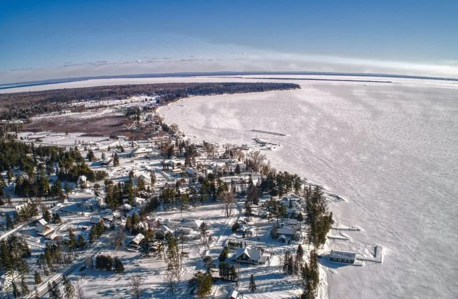 Apostle Islands winter vacation, aerial view of La Pointe covered in snow next to frozen lake