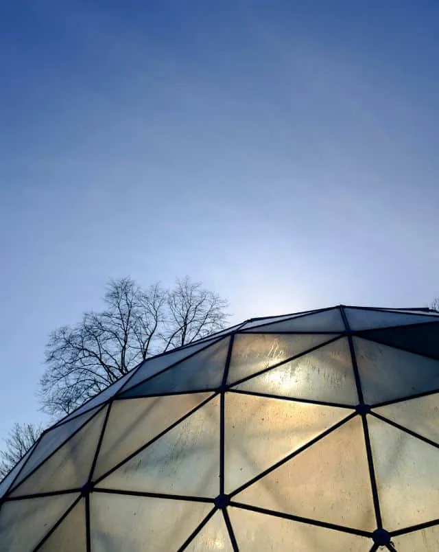 What to do during winter in Madison, WI, top of glass dome lit up from inside under a blue sky