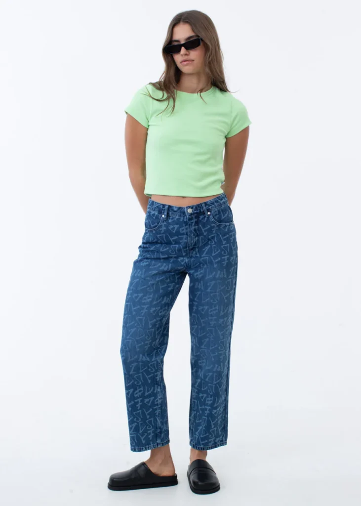 where to buy the best best sustainable jeans, female model wearing blue jeans with random symbols, a light green shirt and sunglasses