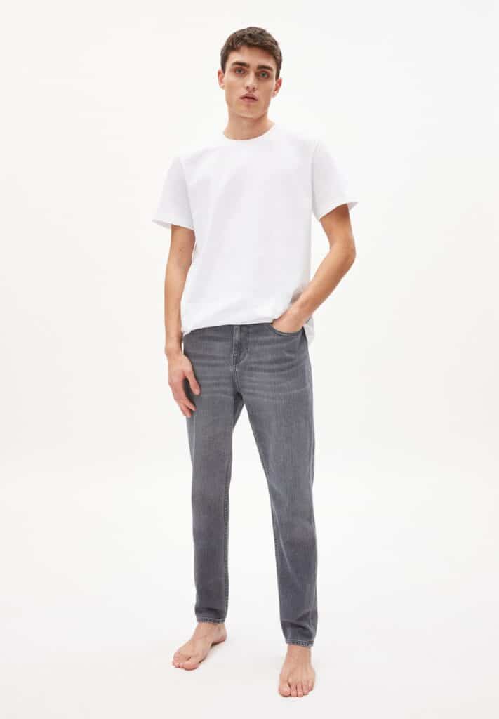 ethical mens jeans, white male model wearing white shirt and faded grey jeans