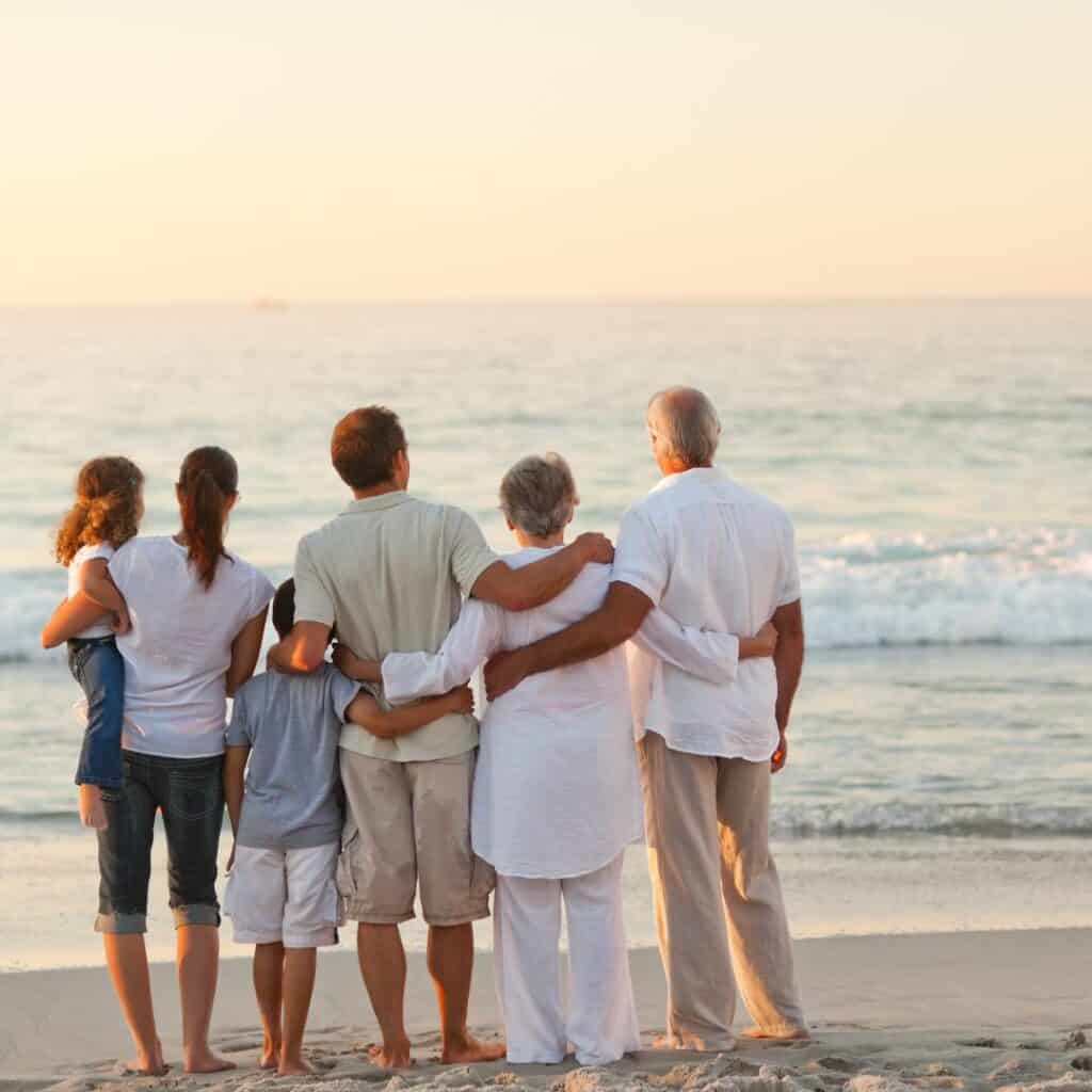 a family of 3 generations looking at the beach together