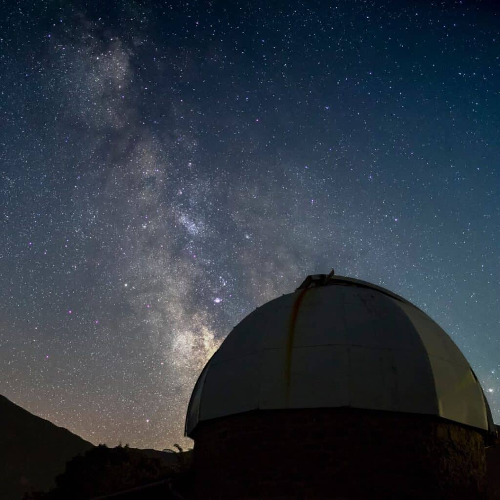 a view of a dome of an observatory at night with a view of the milky way stars