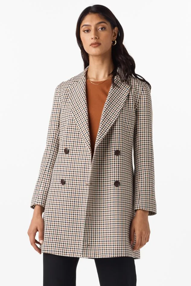 best zero waste clothing companies, woman wearing long checkered blazer over orange top and black pants