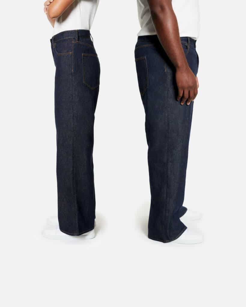 sustainable denim brands, two headless people facing away from each other both wearing white shirts and dark blue jeans