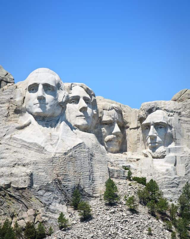 best family road trips from Wisconsin, four heads carved into side of mountain under blue sky