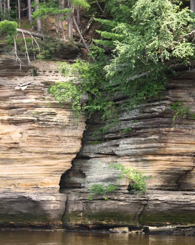 where to go for a road trip around Wisconsin, view of rocky coast with layered wearings on rocky from water