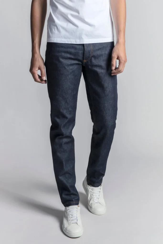 best sustainable denim jeans, bottom half of person wearing dark blue jeans