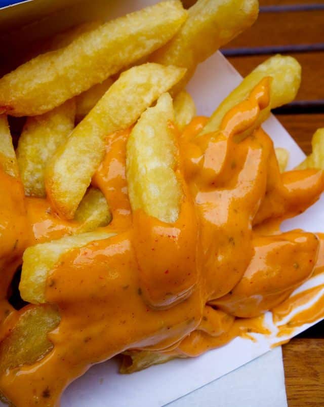 best belgium food in brussels, french fries covered with a spicy orange sauce