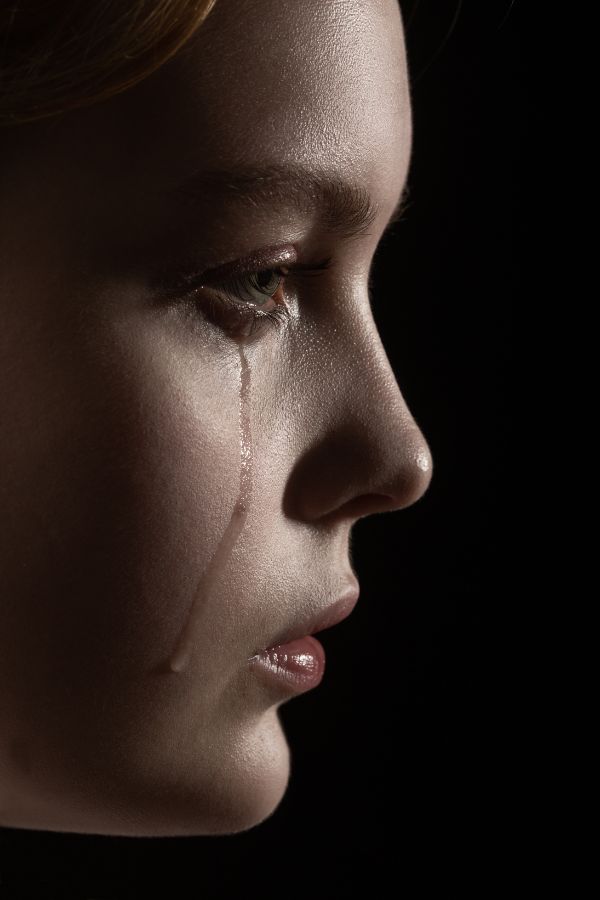 side view of a girl with tears running on her face