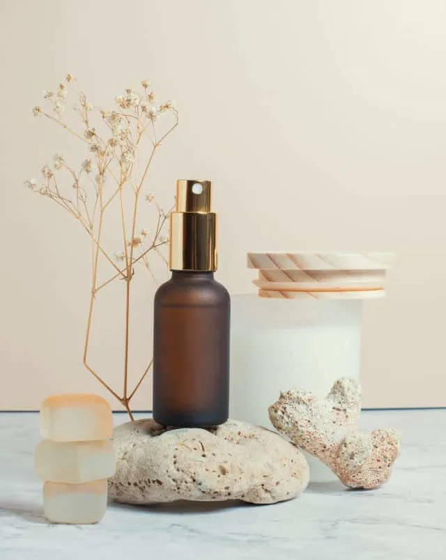 selection of spa items, including spray bottle and porous rocks on top of marble counter