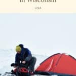 Pin with image of man packing up a backpack outside of a tent in the snow with text at the top reading "15 best witner campsites in Wisconsin" and "USA" in smaller text just below