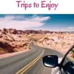 Pin with image of car wing mirror as the car drives down a road surrounded by mountains under a blue sky, text above photo reads "15 top Wisconsin road trips to enjoy"