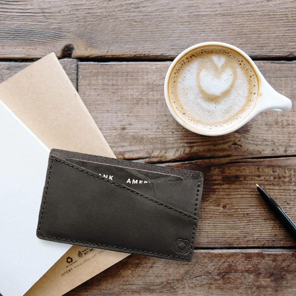 where to get the most sustainable card holder, black cardholder on table next to coffee mug and some documents