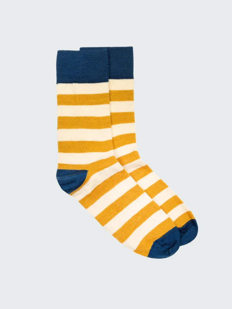 amazing sustainable sock brands, pair of yellow and white striped calf socks with blue highlights around calf, heel and toes