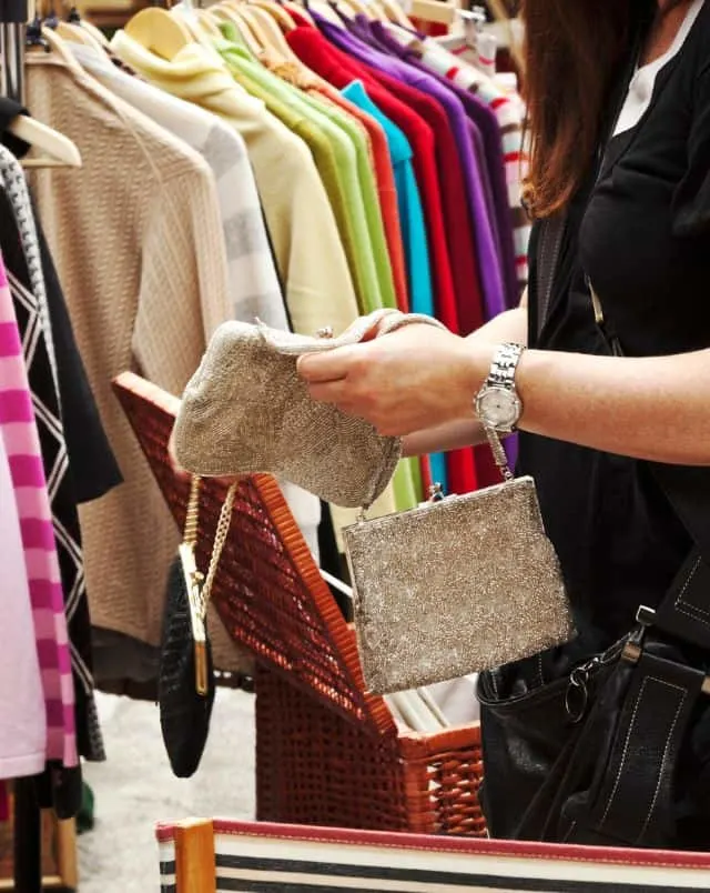 fun holidays in South Tenerife, person reaching into wallet with rack of clothing just behind them