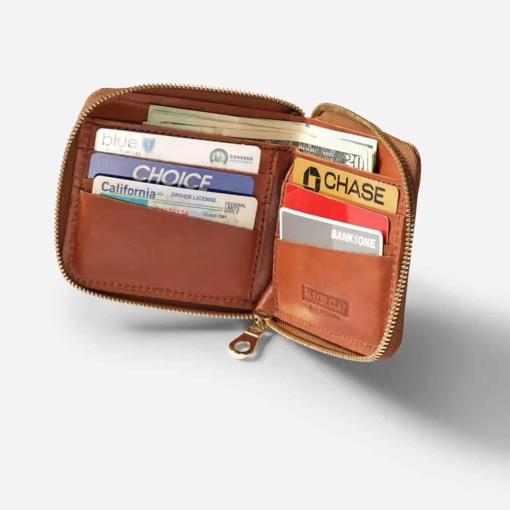 best eco wallets, open small brown leather wallet with money and cards and the brand name parker clay on the inside and and a zipper around the outside