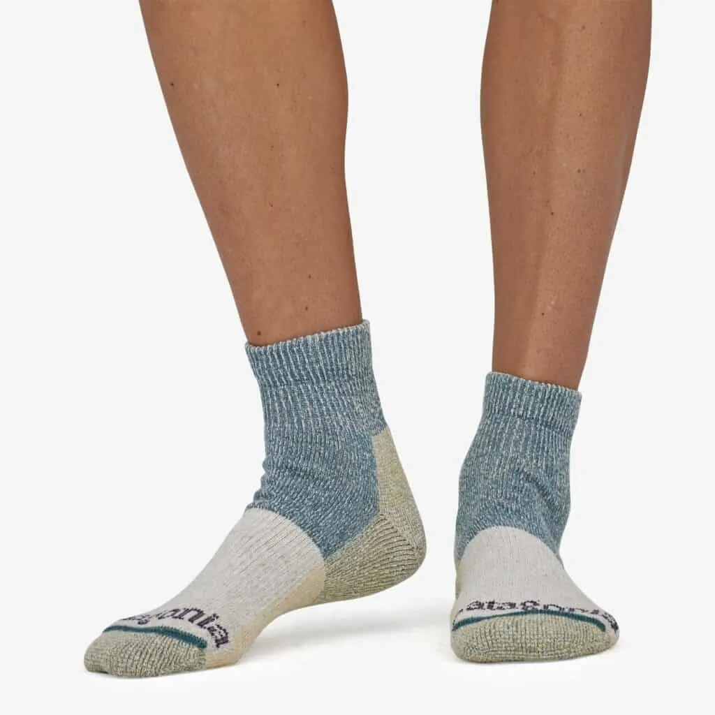 great organic socks, legs of tan person wearing thick ankle socks that are blue, green, yellow and white patches read Patagonia across the toes