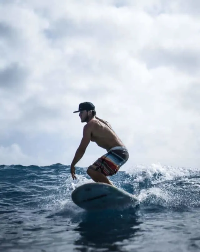 man with baseball cap surfing, surf photography books