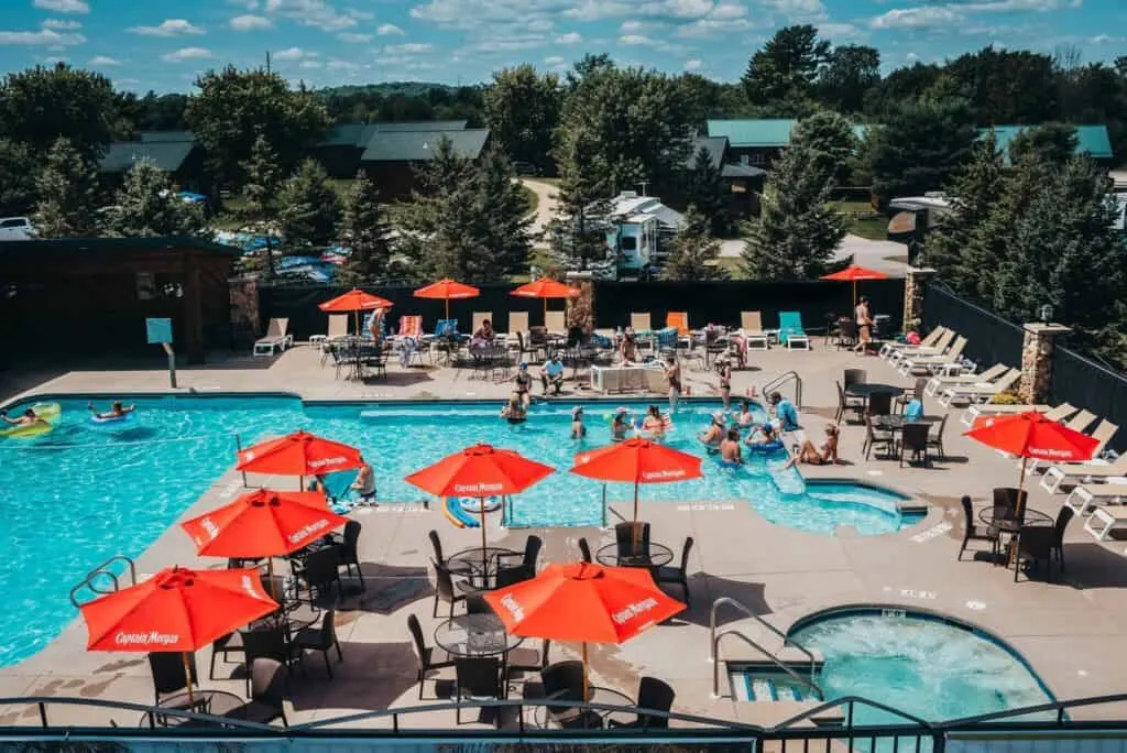 pet-friendly resorts Wisconsin, view from balcony of pool area with tables and chairs and beach umbrellas surrounding a long swimming pool