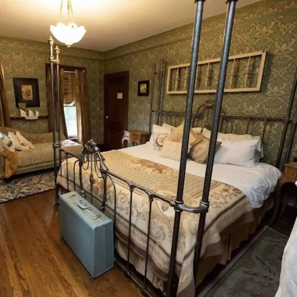 a classic bedroom with a four poster bed in it with green theme and wallpaper