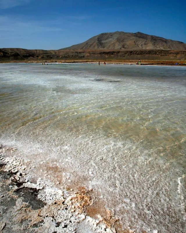 what to do in Cape Verde, close up of salt mine beach with mountains in the distance