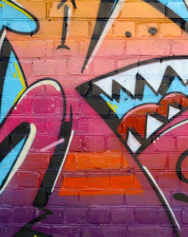 Find out what to do in Eau Claire, WI this summer, close up of colourful street art patined onto brick wall