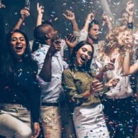 Try some of these things to do in the Dells for adults, group of young people partying and smiling and holding drinks while confetti rains around them