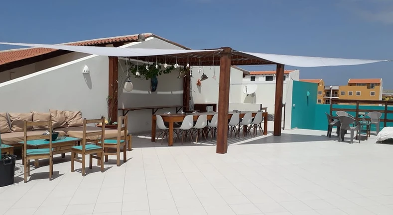 Outdoor bar area with covered tables and chairs and some soft sofa areas to one side