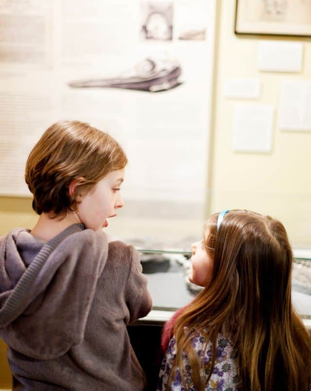 fun things to do in La Crosse WI for kids, Close up of two young children sharing a moment of excited surprise and discovery whilst inside a children's musem