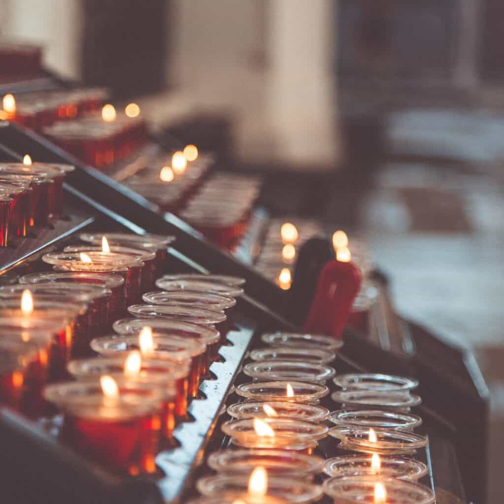 a row of lit candles in a church
