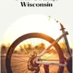 Pin with image of the back half of a bike backlit by sunset light, text above image reads: Top 8 bike trails in Door County Wisconsin