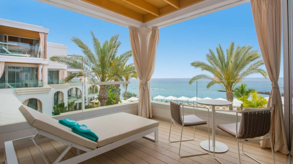 5 star hotels in tenerife adults only all inclusive, balcony of a hotel room equipped with a deck chair, towels and a table with chairs with view out over ocean