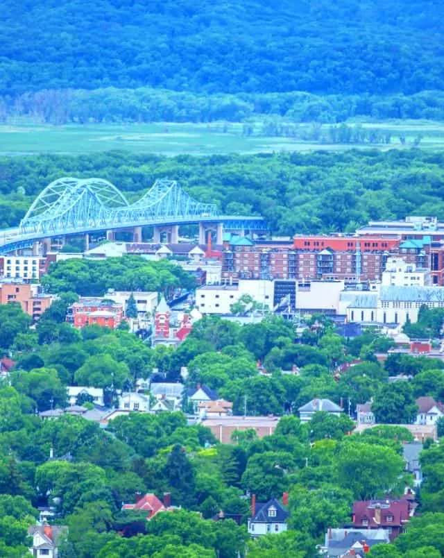 fun things to do in La Crosse Wisconsin, view looking across a valley with buildings and a bridge surrounded by green trees with a large green hill behind