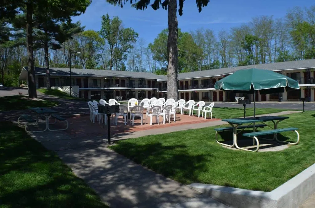 Wisconsin Dells Resorts For Couples, exterior of a resort with outside seating and picnic area under a blue sky