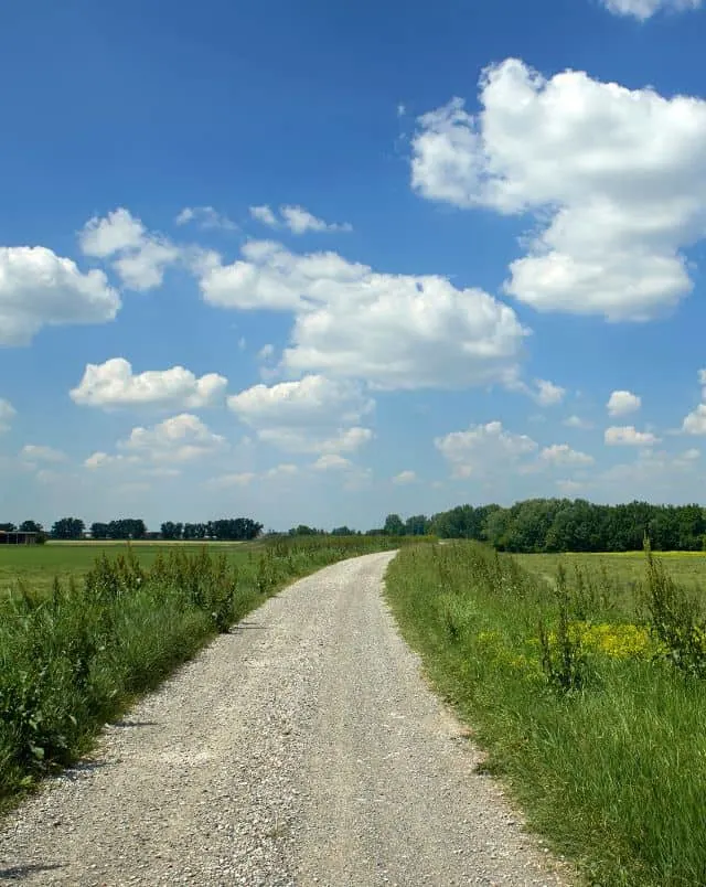 Try out these Oshkosh activities, long gravel bike path leading through a field of green grass on a bright sunny day under a wide blue sky with fluffy white clouds